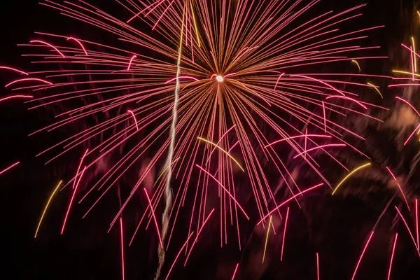 Multiple Fireworks Creating Red and Pink Trails image