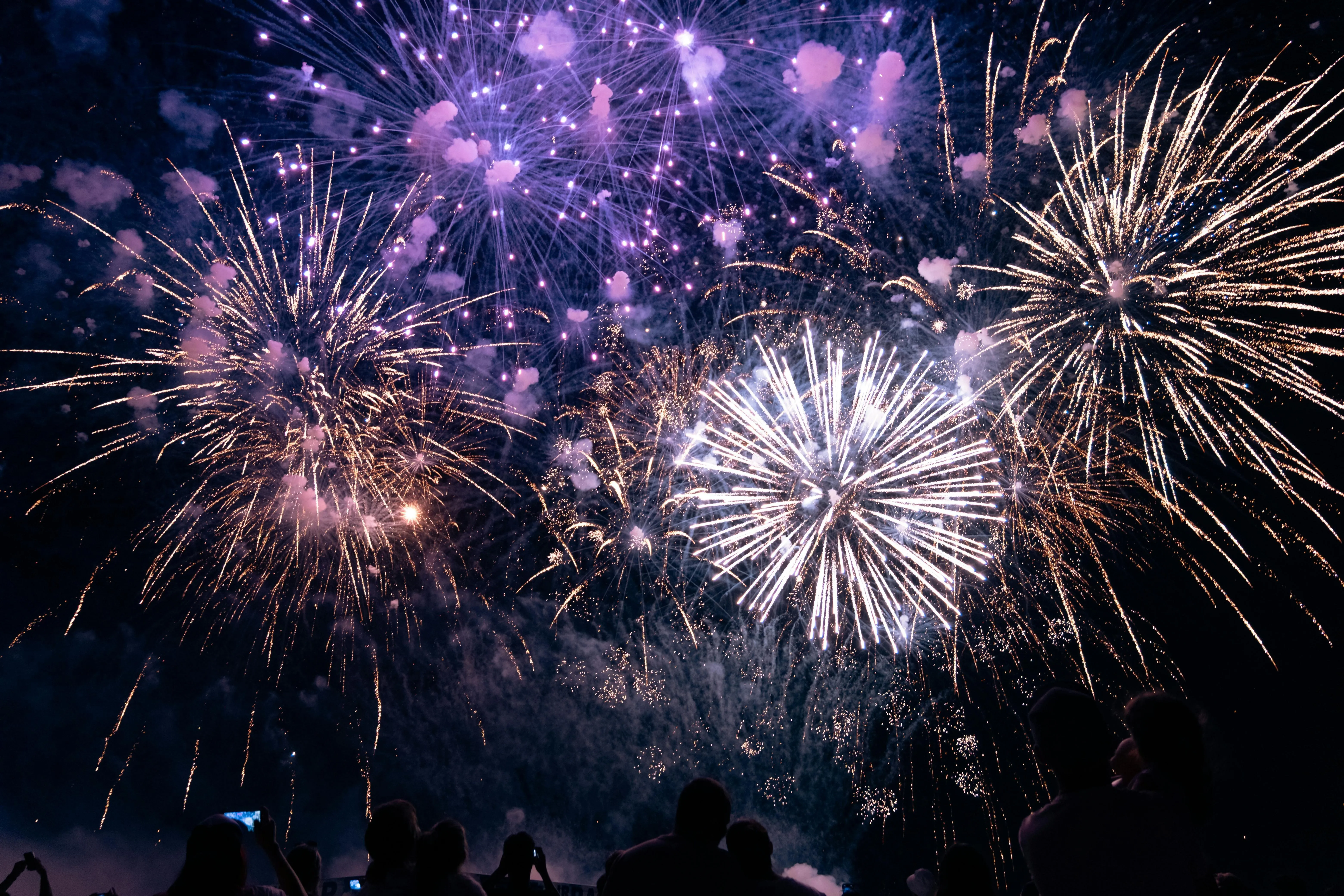 Nighttime Sky Filled with Bright Bursts of Fireworks