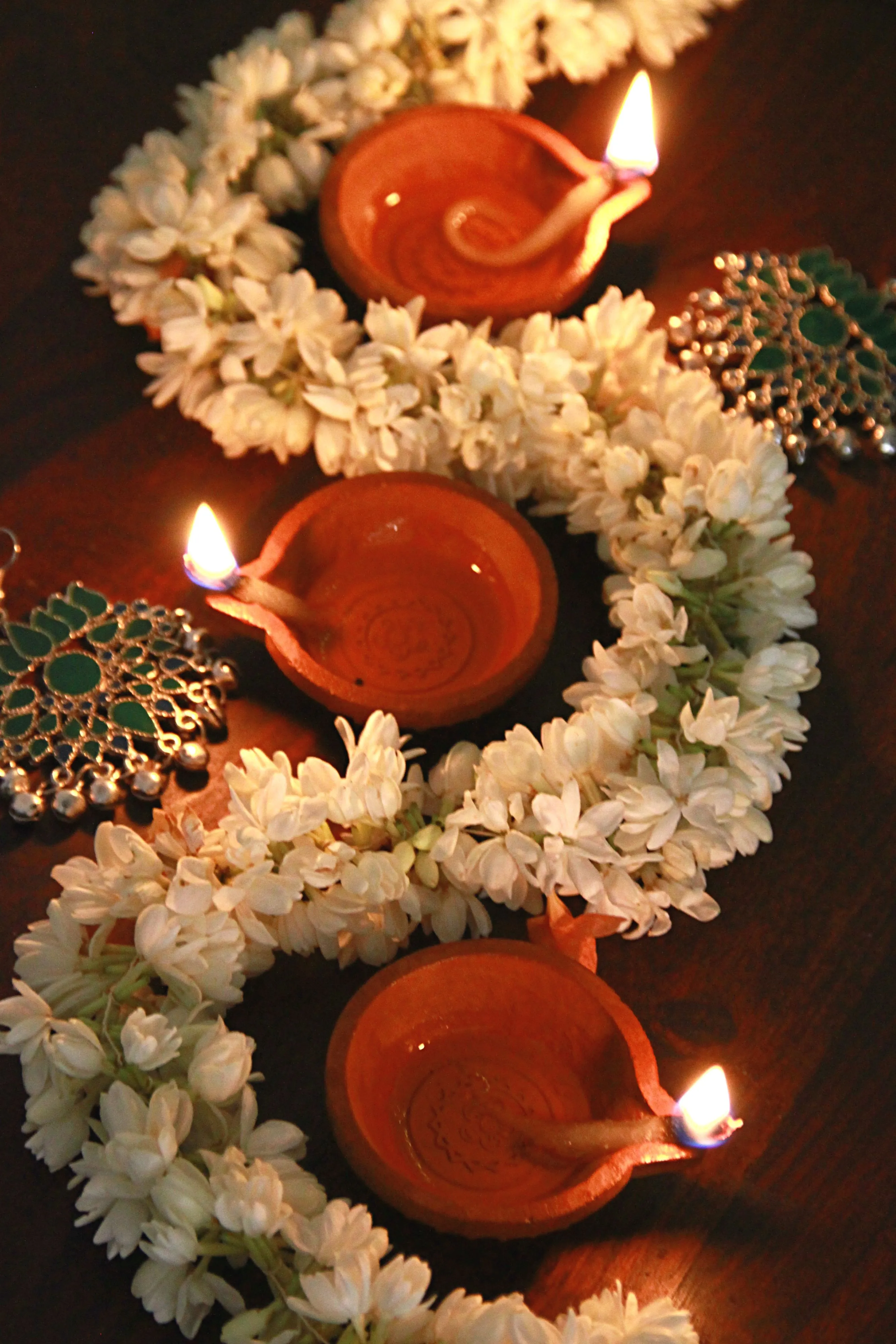 Onam decoration with oil lamps and jasmine flowers image