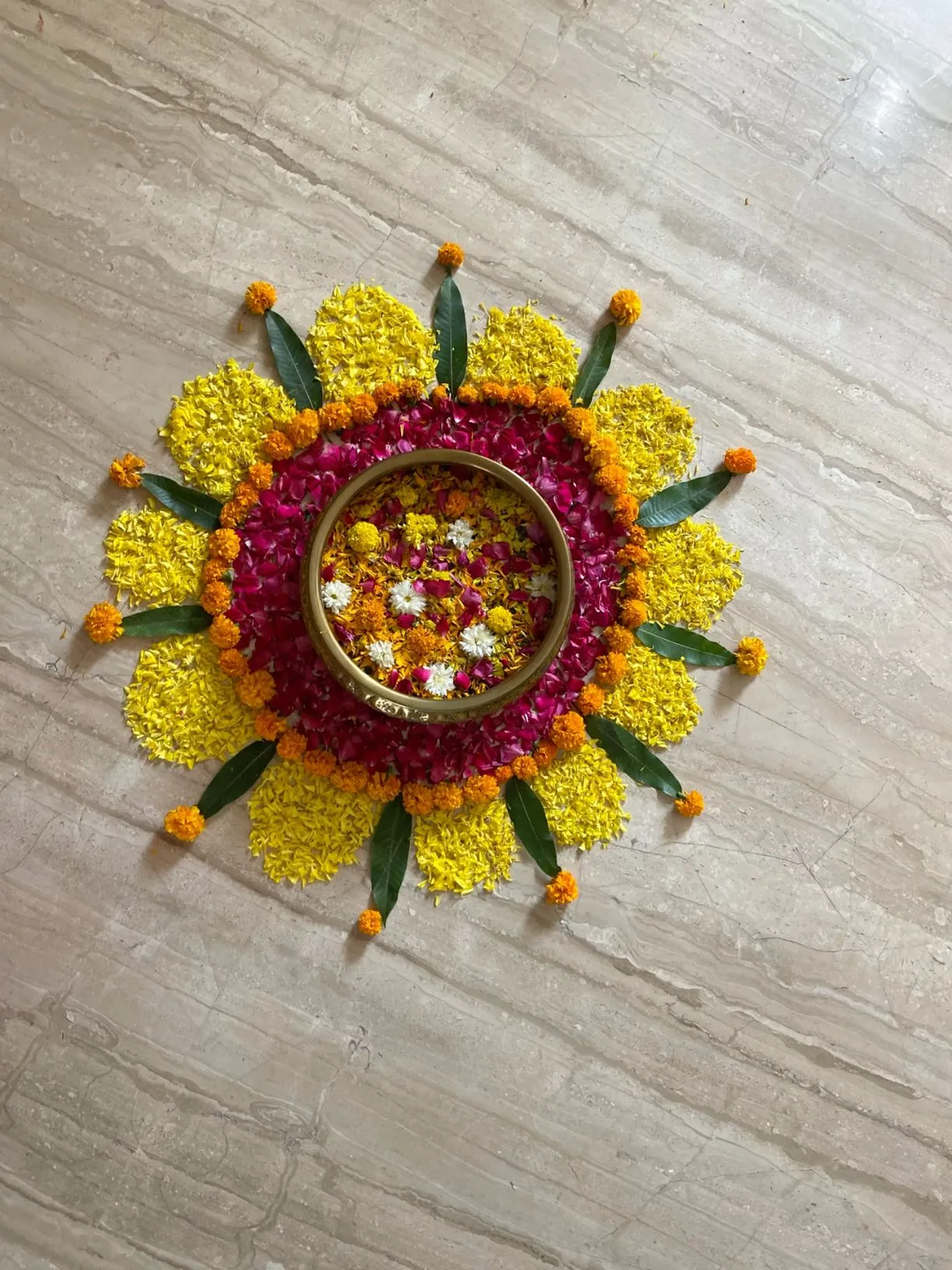 Onam kolam decoration with traditional vessel at the center