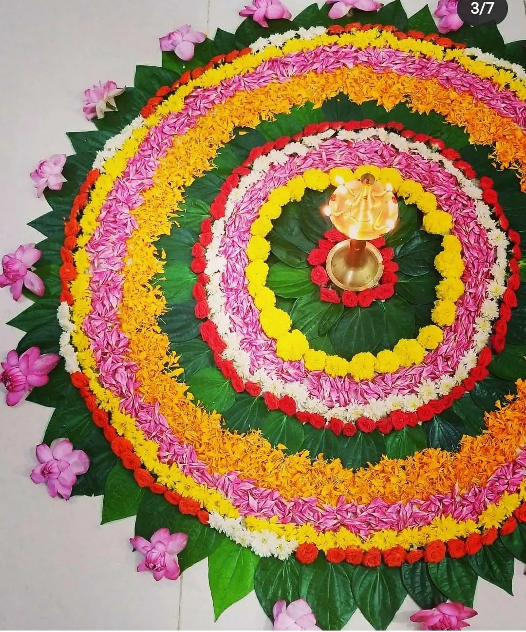 Onam pookolam with green leaf base and lotus border image