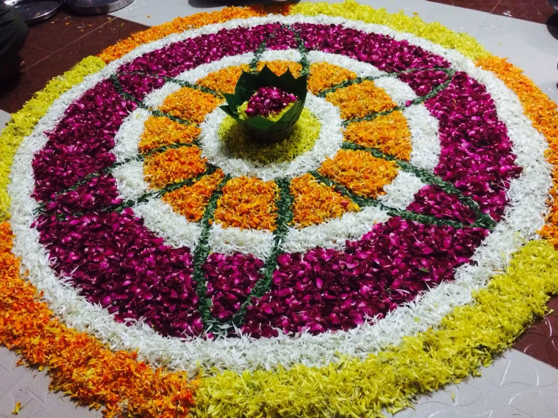 Onam pookolam with vibrant flower petal decoration image