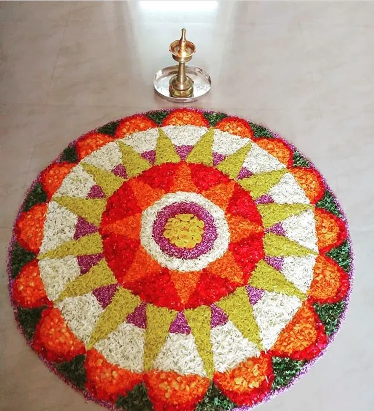 Orange and green circular pookolam with Traditional lamp
