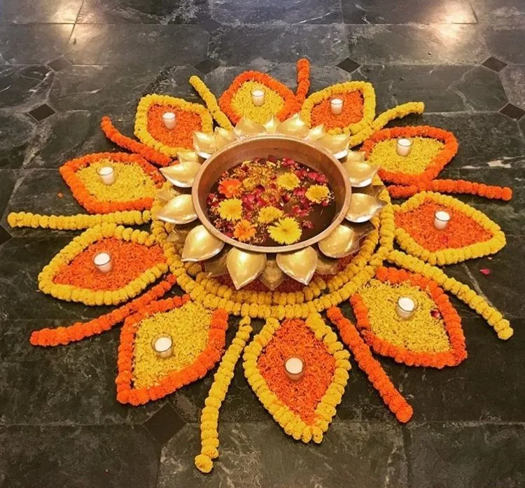 Orange and yellow pookolam with floating flower bowl image