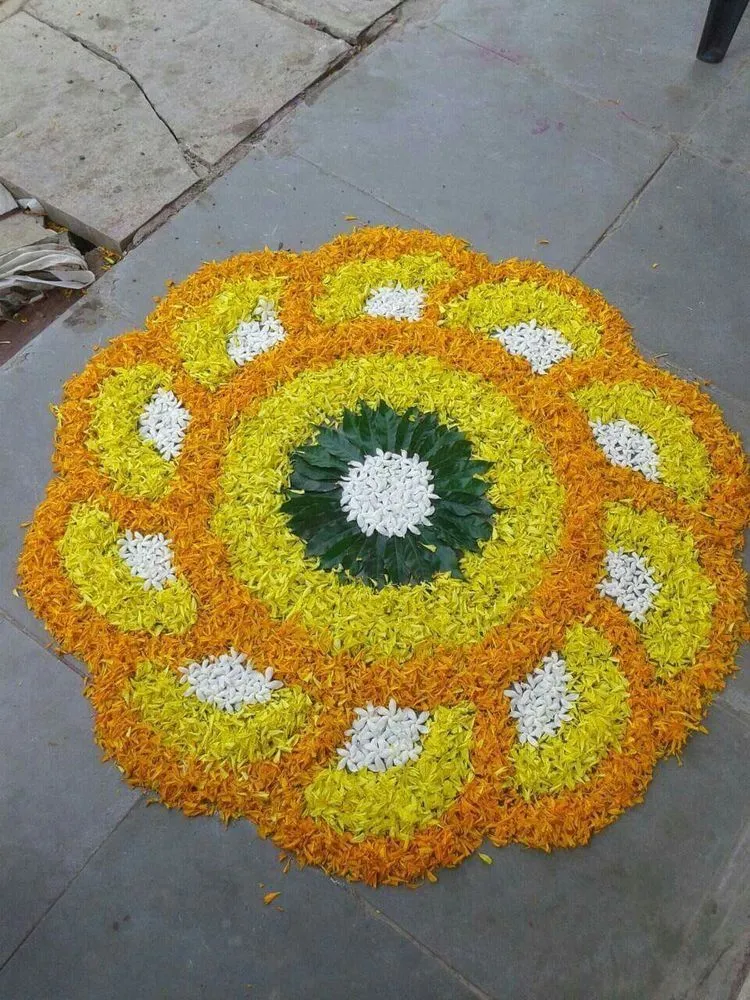 Orange and yellow spiral petal kolam design with white center