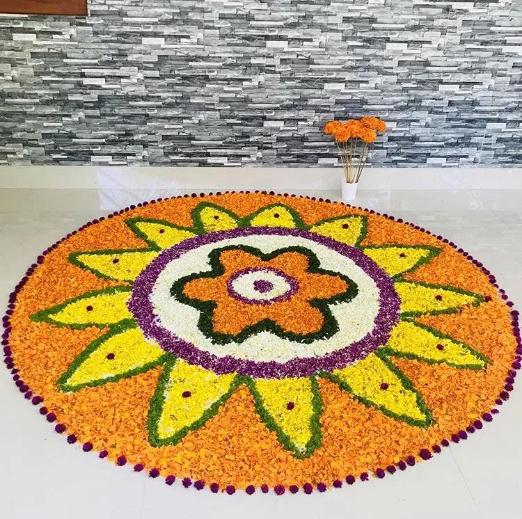 Orange circular pookolam with dotted purple border design