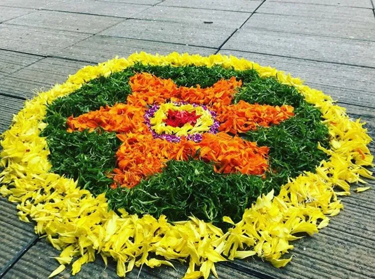Orange star kolam with green and yellow concentric circles