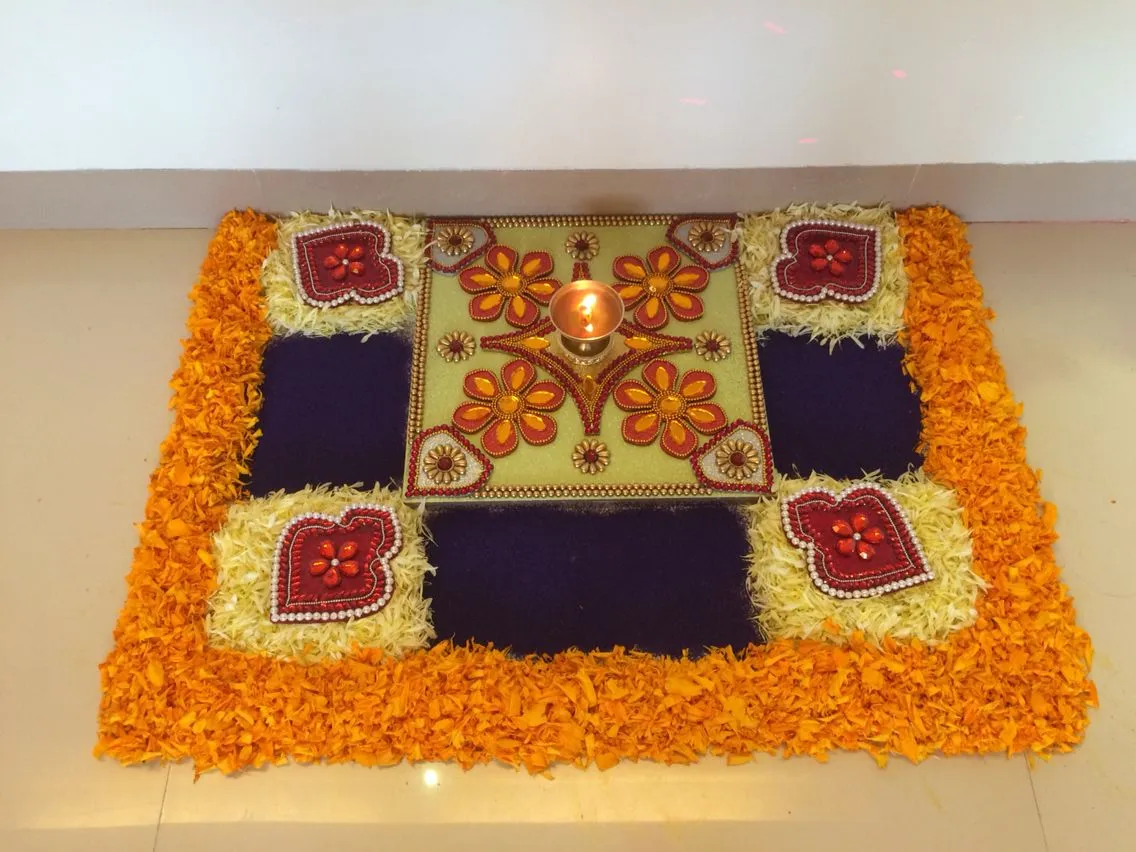 Orange with white petals kolam in a square with beads image