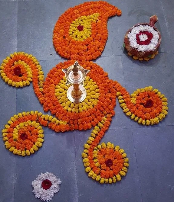 Paisley flower rangoli with marigolds and a brass lamp HD