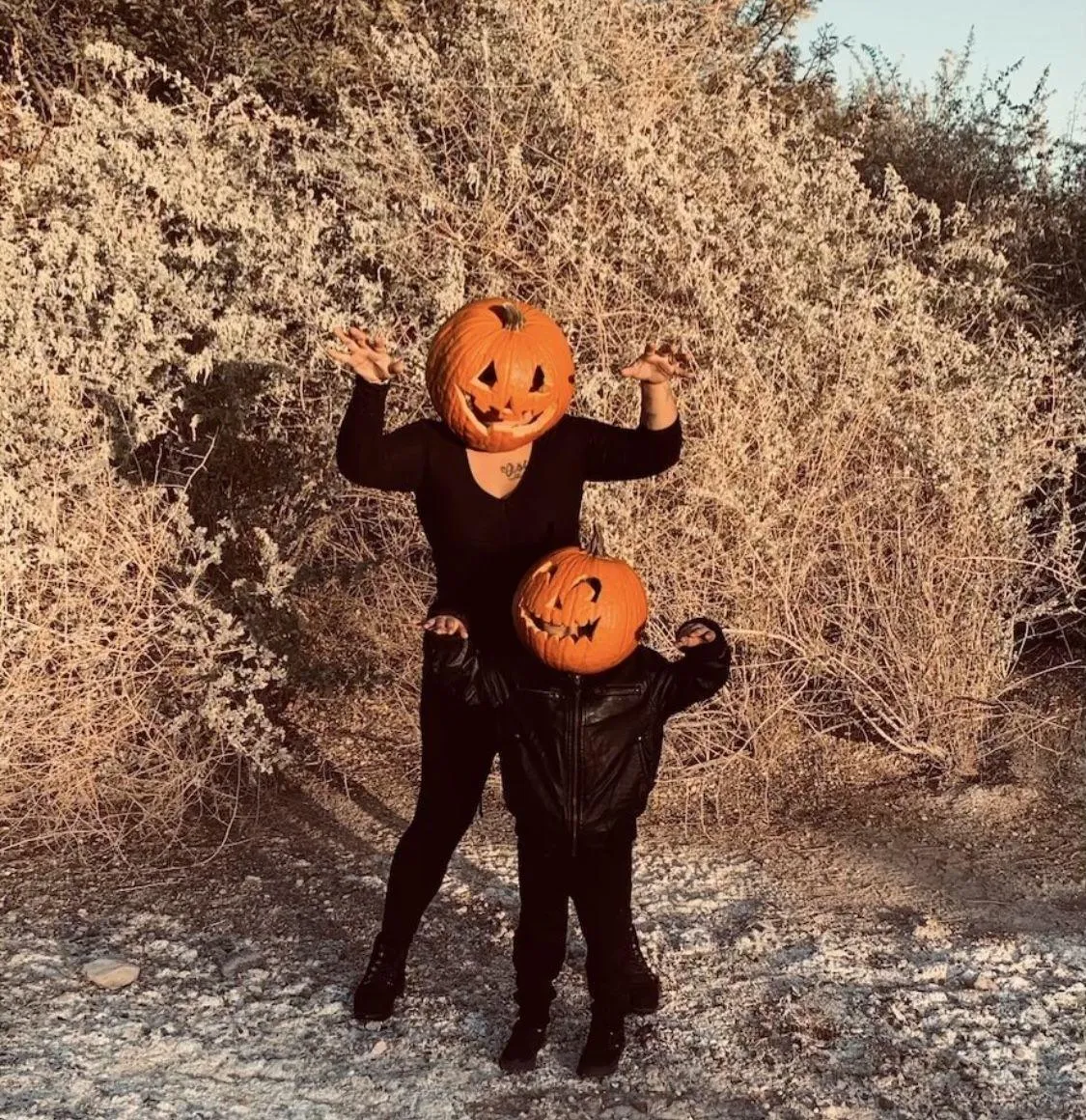 Parent and Child in Pumpkin Heads Hugging in Dry Field