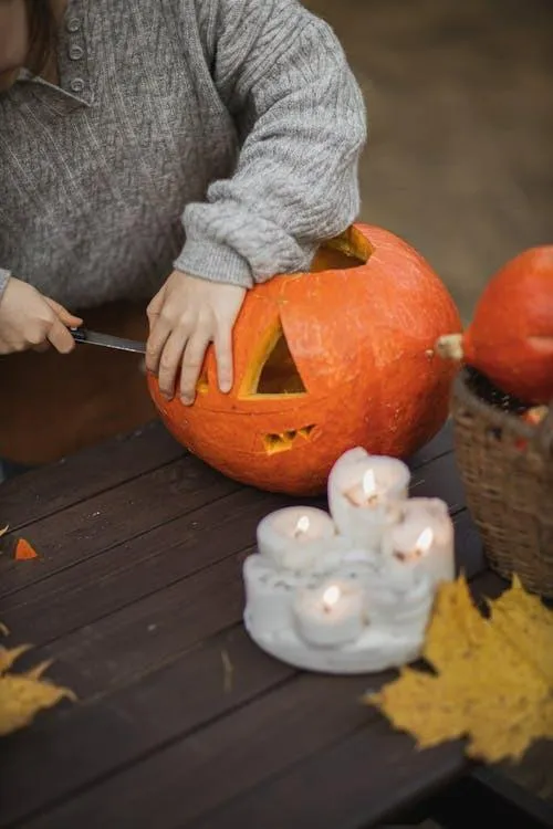 Person Carving Pumpkin Near Halloween Candle Setup HD
