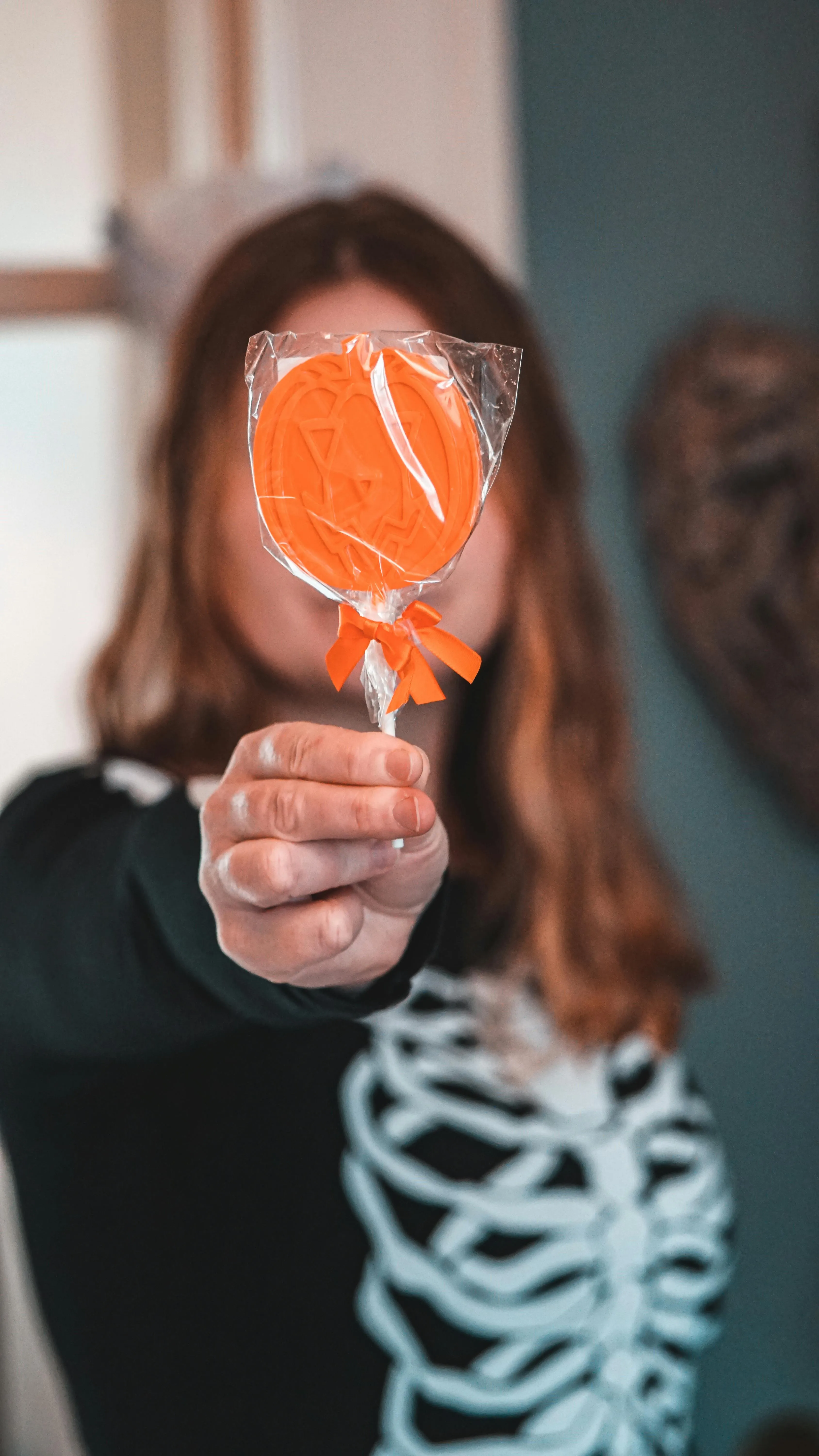 Person Holding Halloween Pumpkin Lollipop Wallpaper