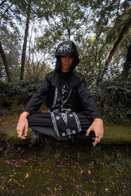 Person in black halloween costume sitting in log image
