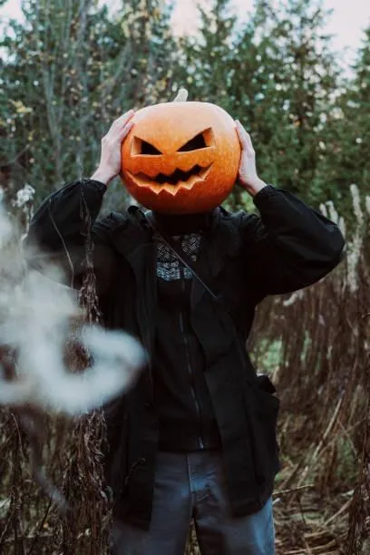 Person in Pumpkin Head Costume with Halloween Fog Effect