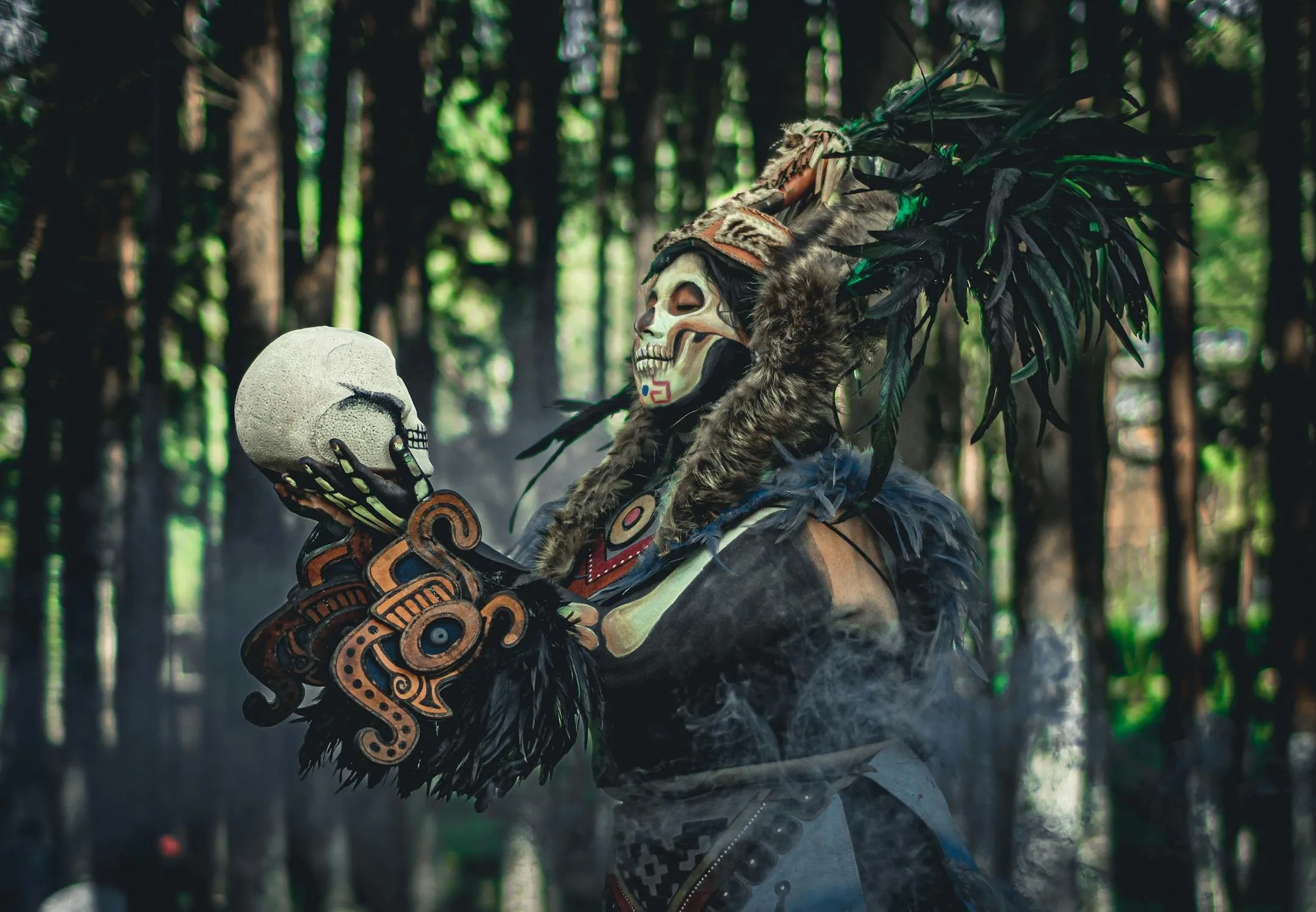 Person in Tribal Skull Costume Holding Skull Prop in Forest