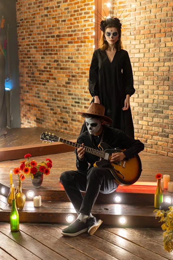 Person Sitting Indoors with Guitar and Halloween Decorations