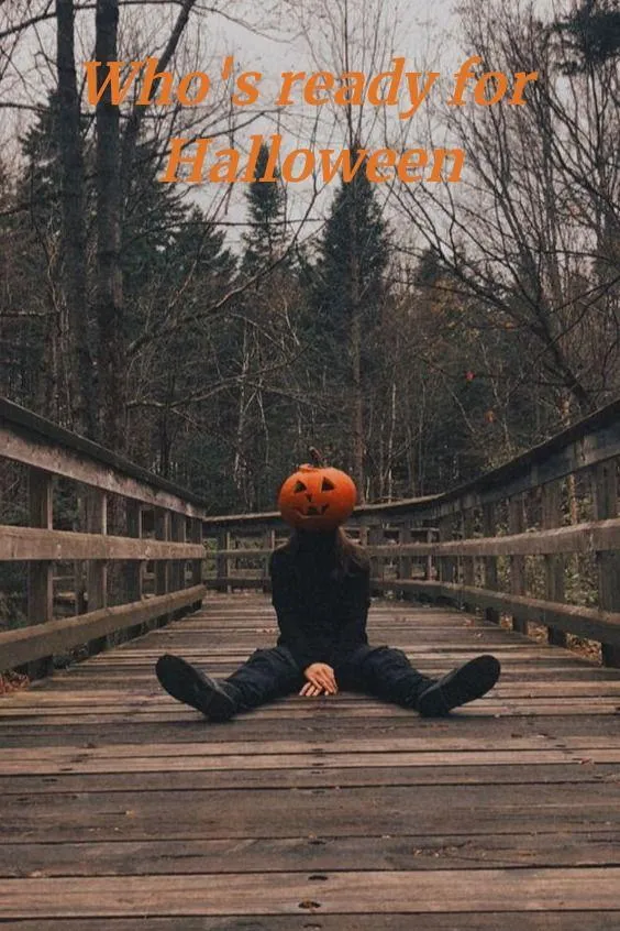 Person Sitting on Bridge Wearing Pumpkin Head Mask