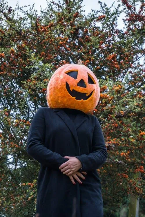 Person Standing with Pumpkin Head Mask in Forested Area HD