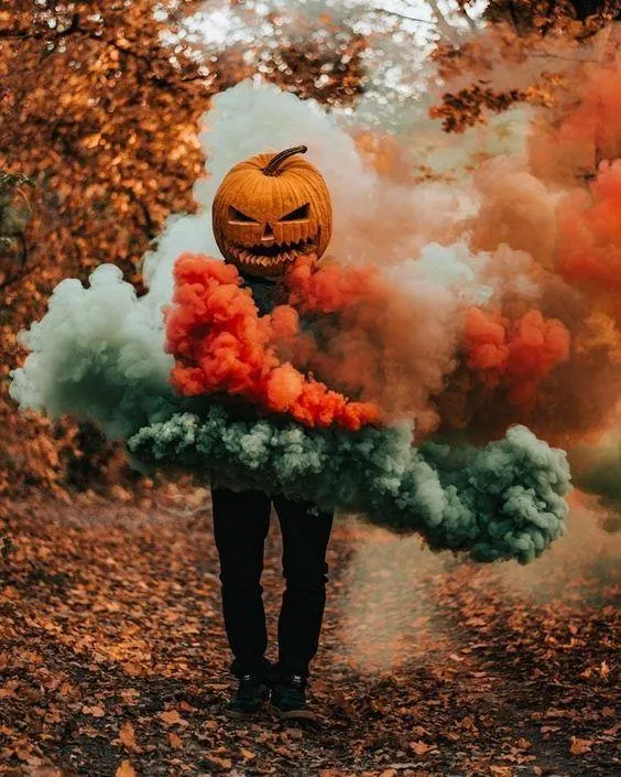 Person Wearing Pumpkin Head Surrounded with smoke in Autumn