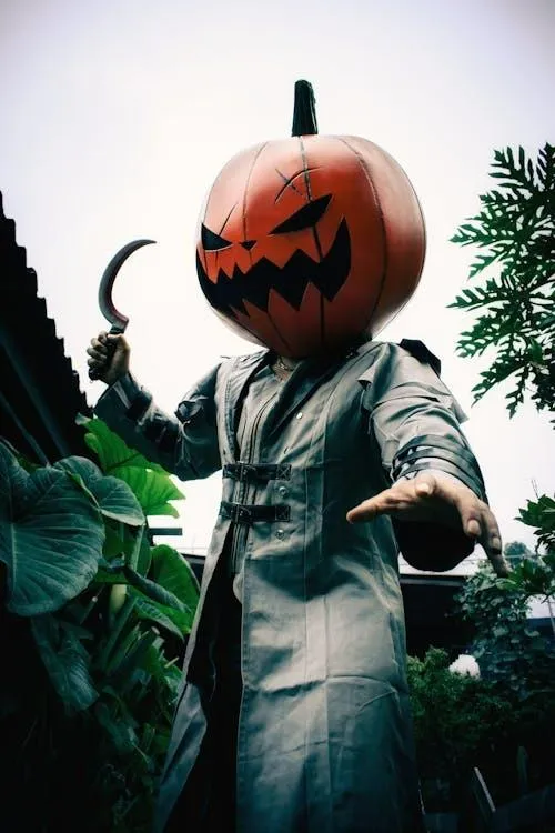Person Wearing Pumpkin Mask and ling Coat Wallpaper