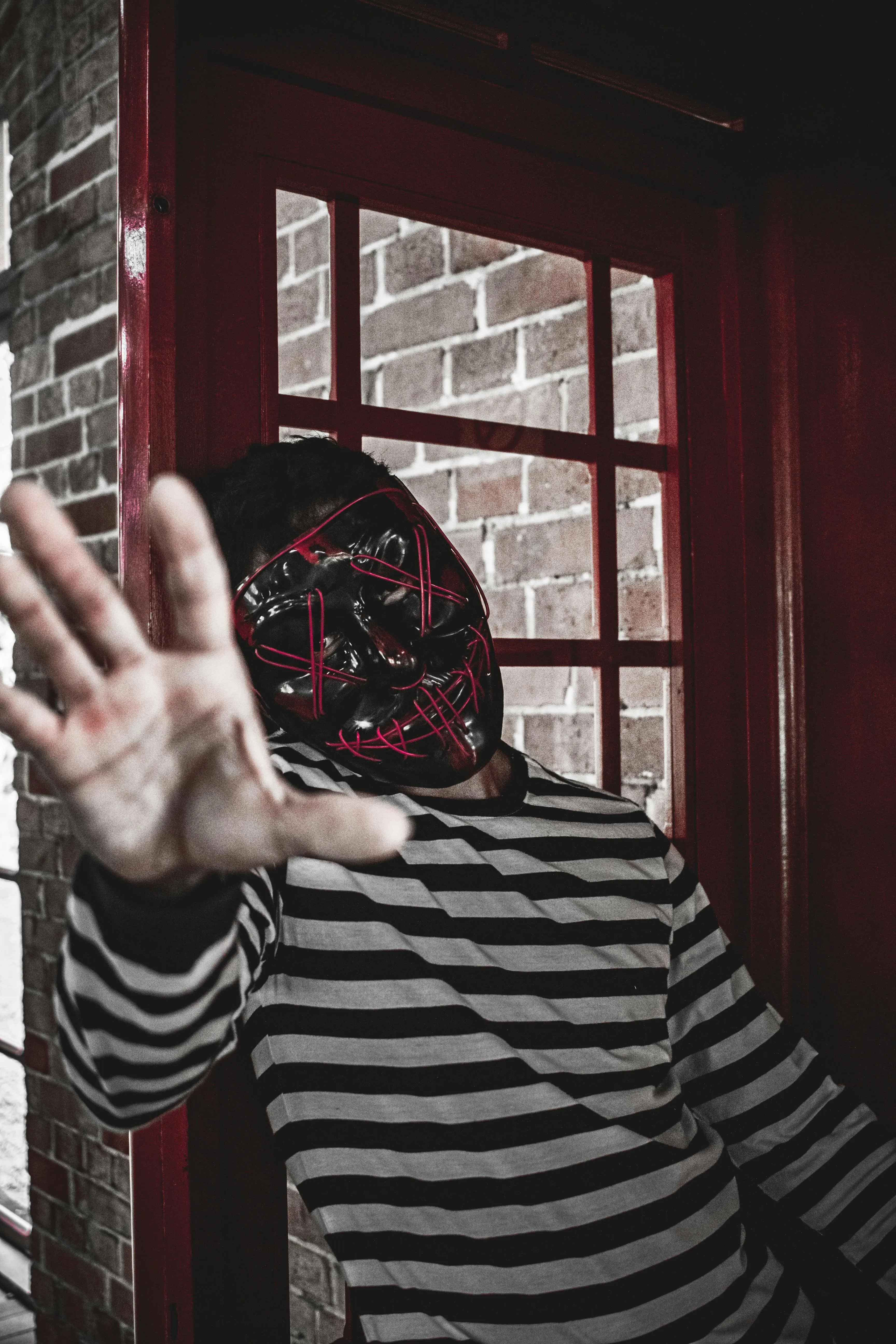 Person Wearing Striped Shirt and Red Skull Mask Wallpaper