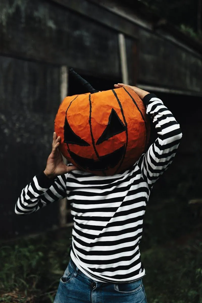 Person Wearing Striped Shirt with Pumpkin Head Covering