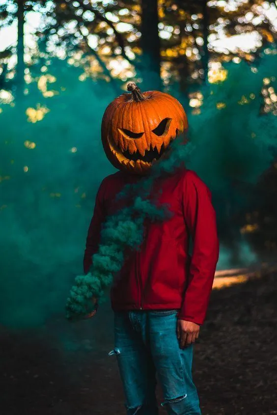 Person with Pumpkin Head and Green Smoke for Halloween