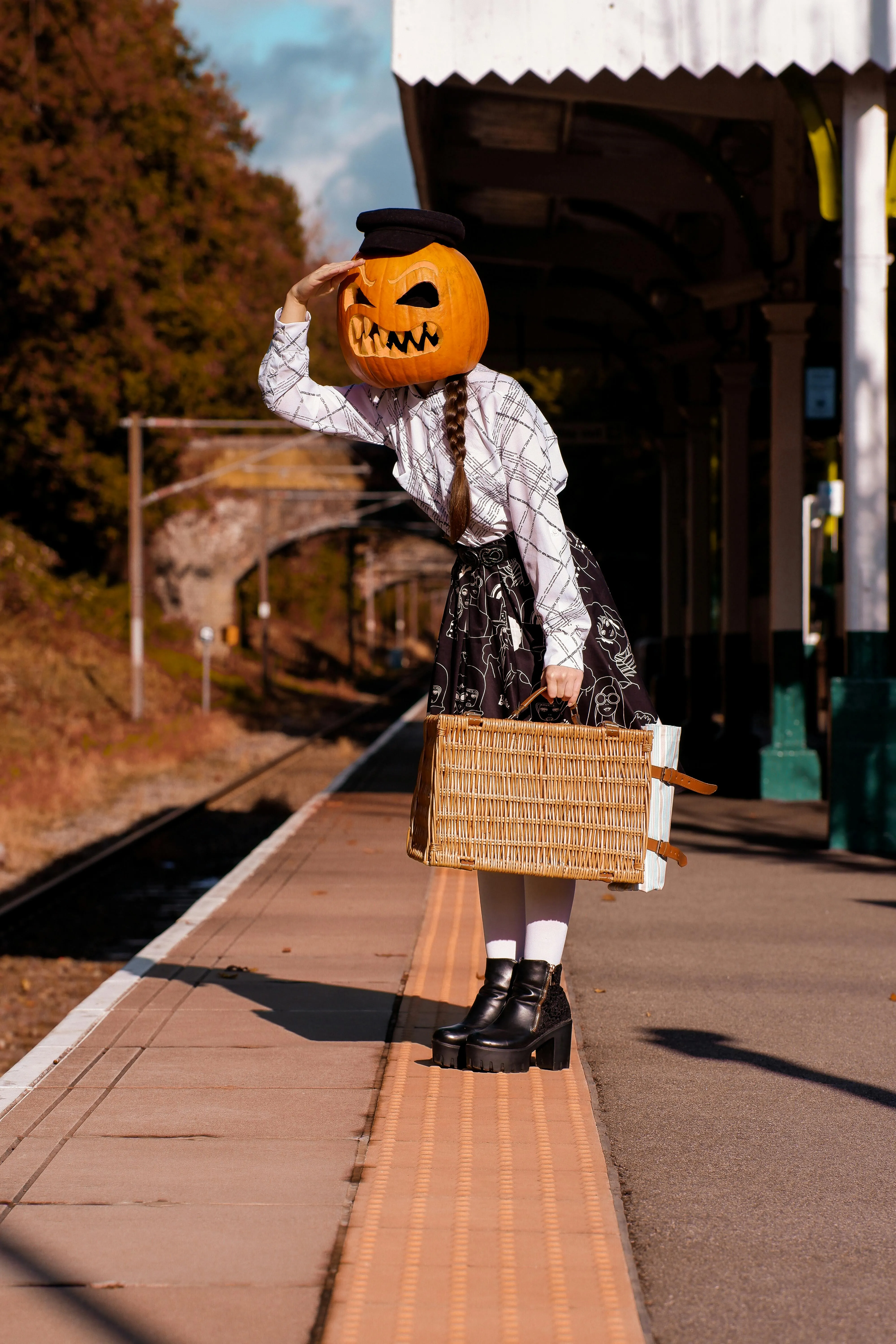 Person with Pumpkin Head Carrying Basket on railway station