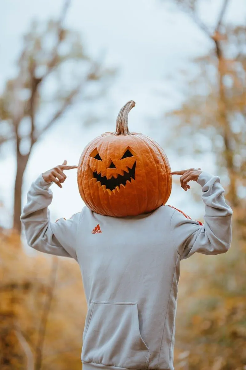 Person with Pumpkin Head in Autumn Setting for Halloween