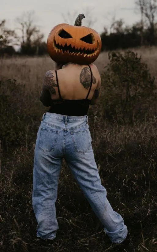 Person with Pumpkin Head in Halloween Festival Scene