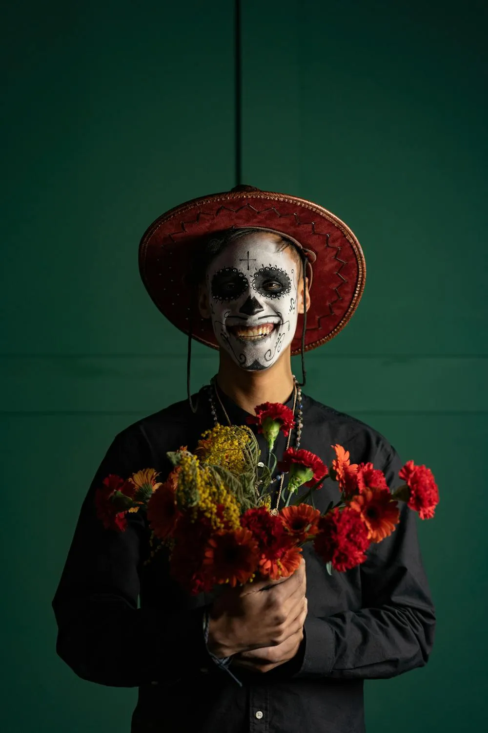 Person with Sugar Skull Makeup Holding Red Flowers HD