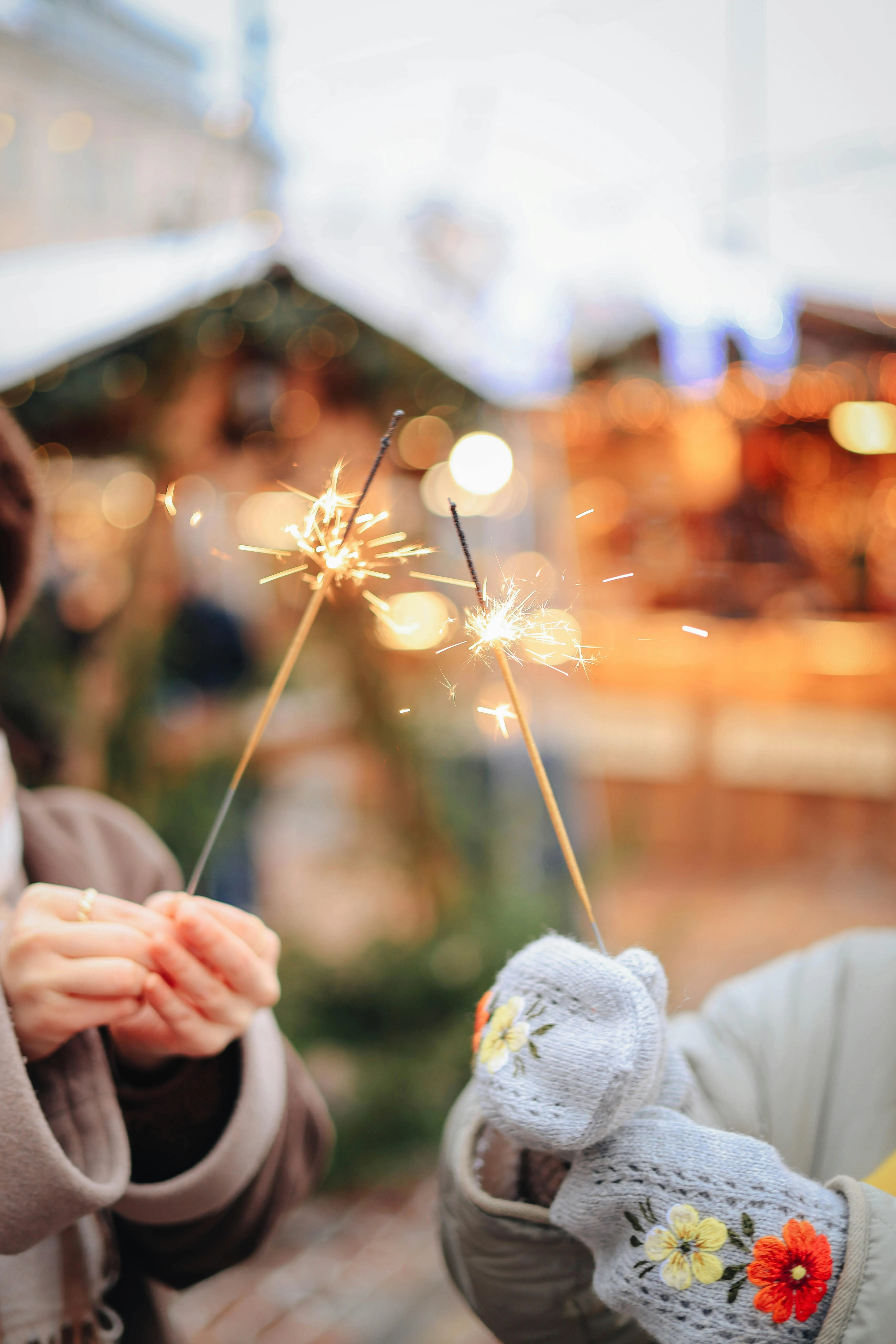 Persons holding a sparkler at night during a celebration