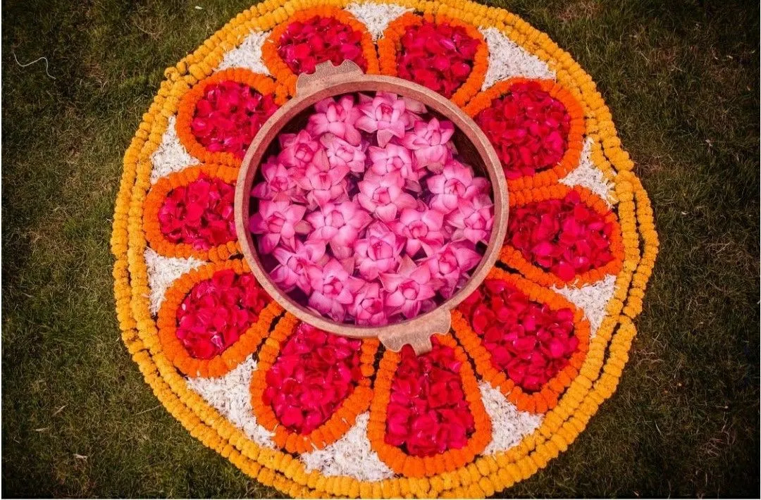 Pink lotus pot with marigold floral design pookolam image
