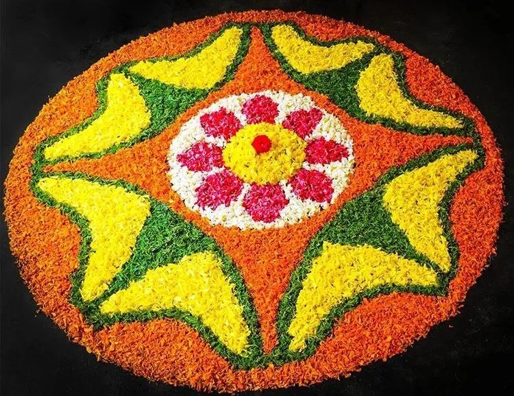 Pookolam with orange circular petal base with star pattern