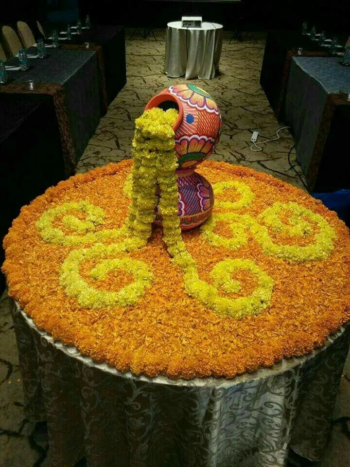 Pot pookolam decoration with marigolds flowing from it image