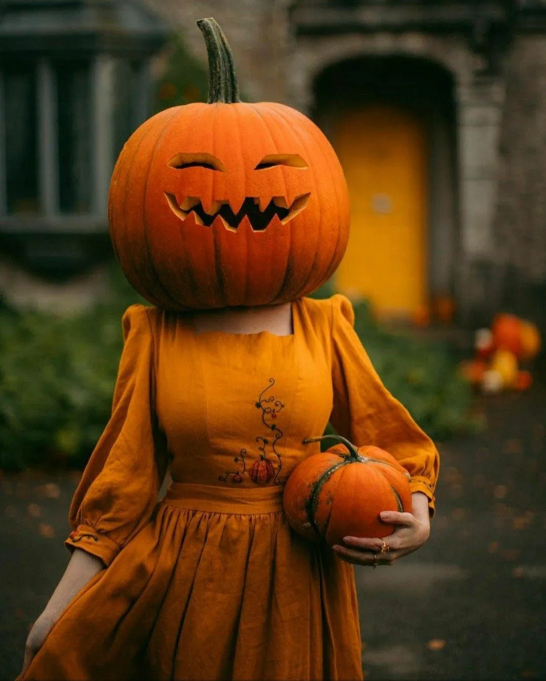 Pumpkin Head in Orange Dress Standing Outdoors Wallpaper