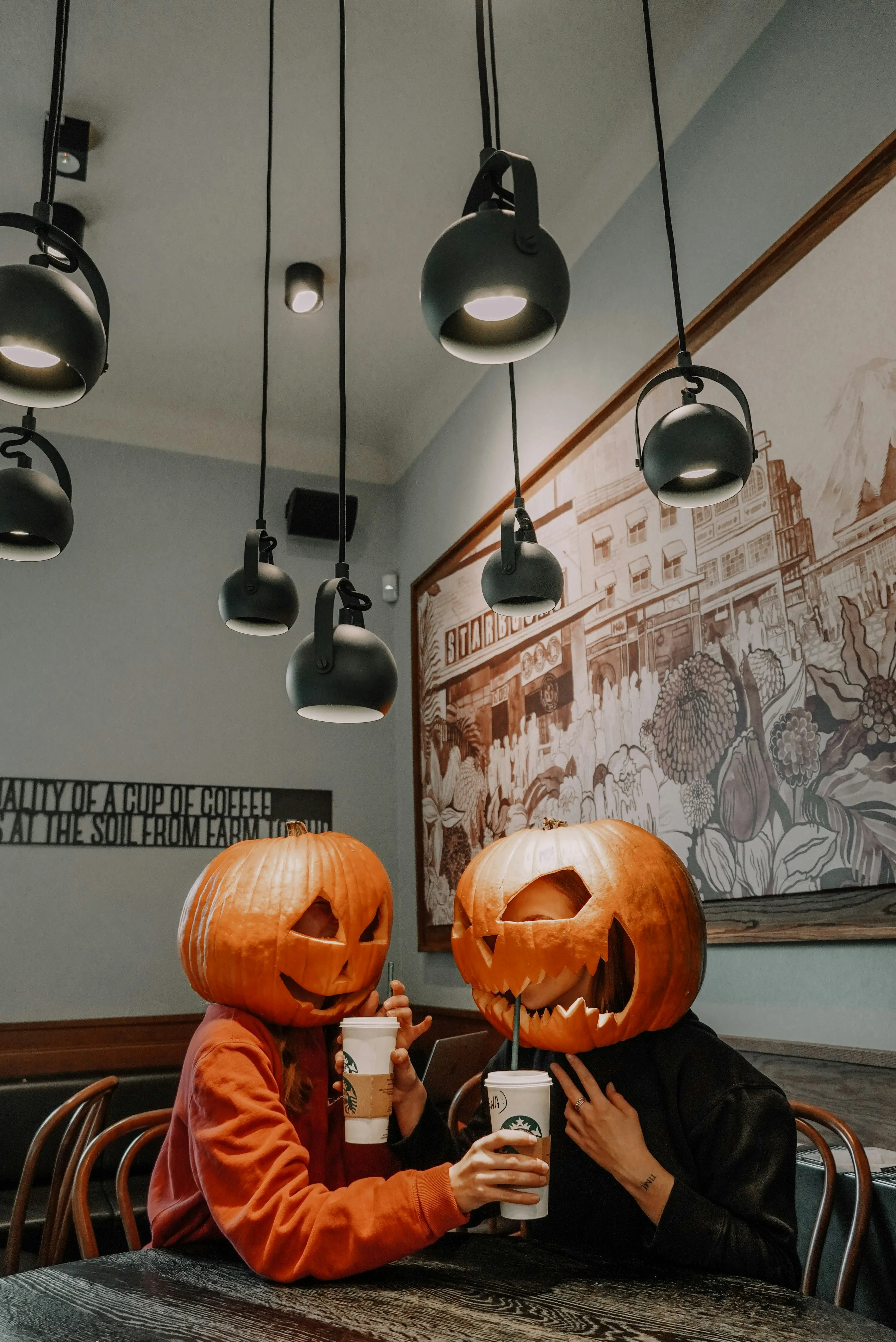 Pumpkin Headed Couple Having Coffee Indoors Wallpaper