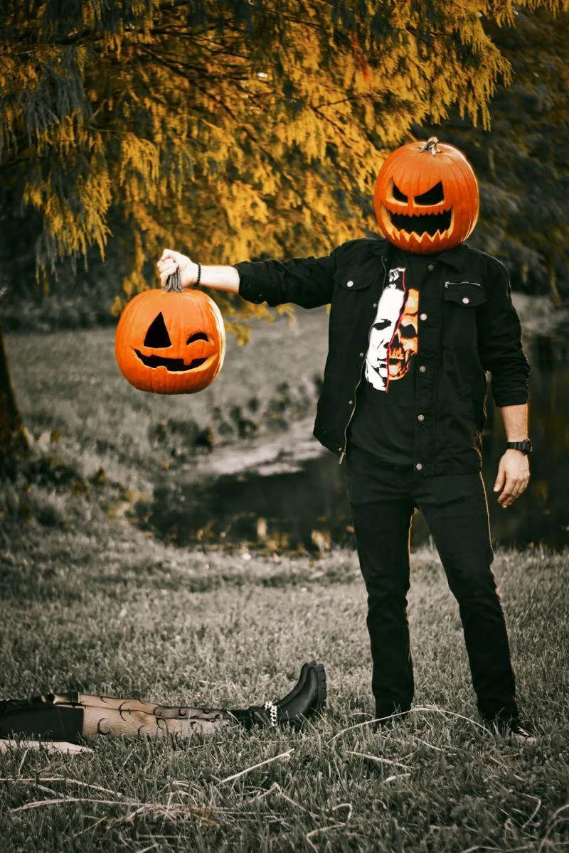 Pumpkin Headed Figure Holds Jack o Lantern by Mysterious Scene