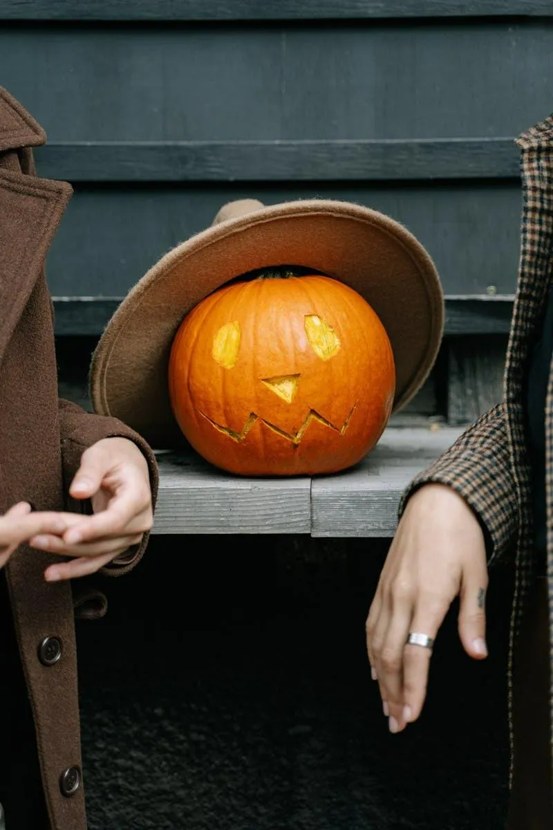 Pumpkin with Hat and Jacket Display Between Two Hands
