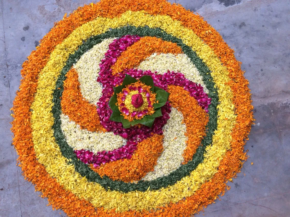 Purple with orange spiral circular design Athapookolam image