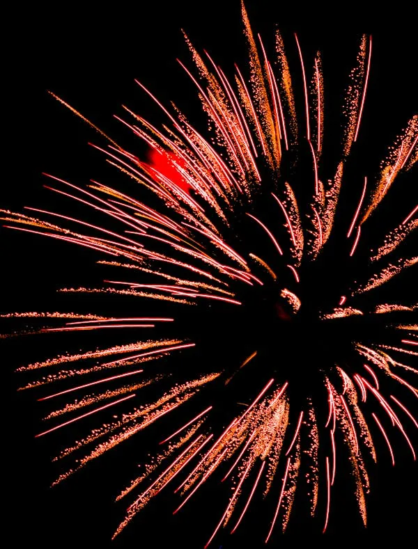 Red and orange fireworks bursting in a dark sky Wallpaper