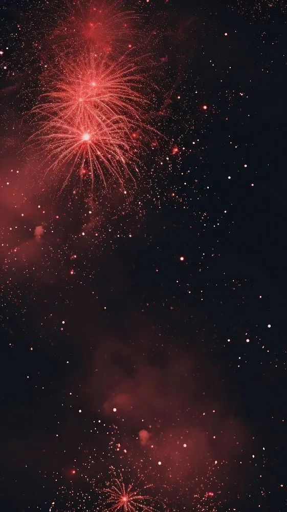 Red and Orange Fireworks Bursting in the Sky at Night
