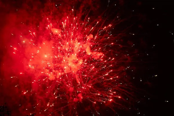 Red Firework Bursting with Intense Glow in Dark Night