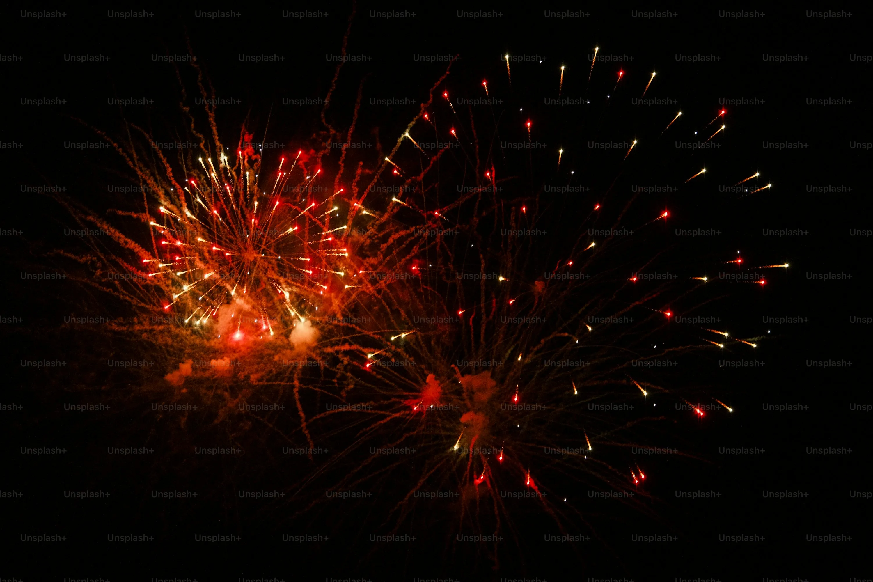 Red Fireworks Bursting in the Dark Sky with Bright Trails