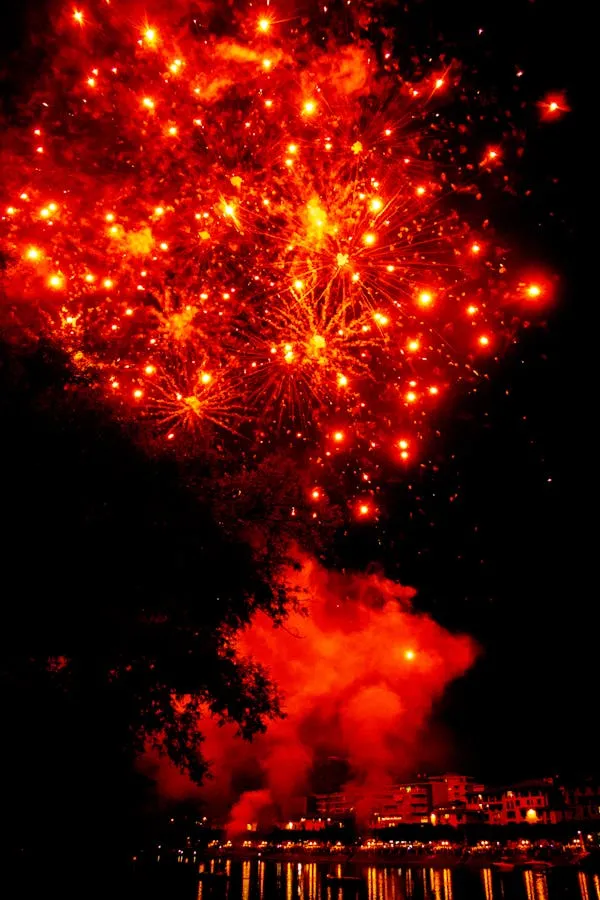 Red Fireworks Exploding above a City Landscape Wallpaper