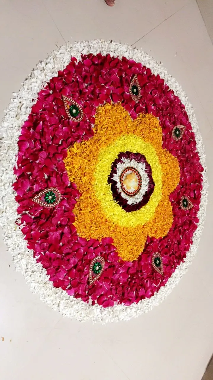 Red with white border circular kolam with decorative bead