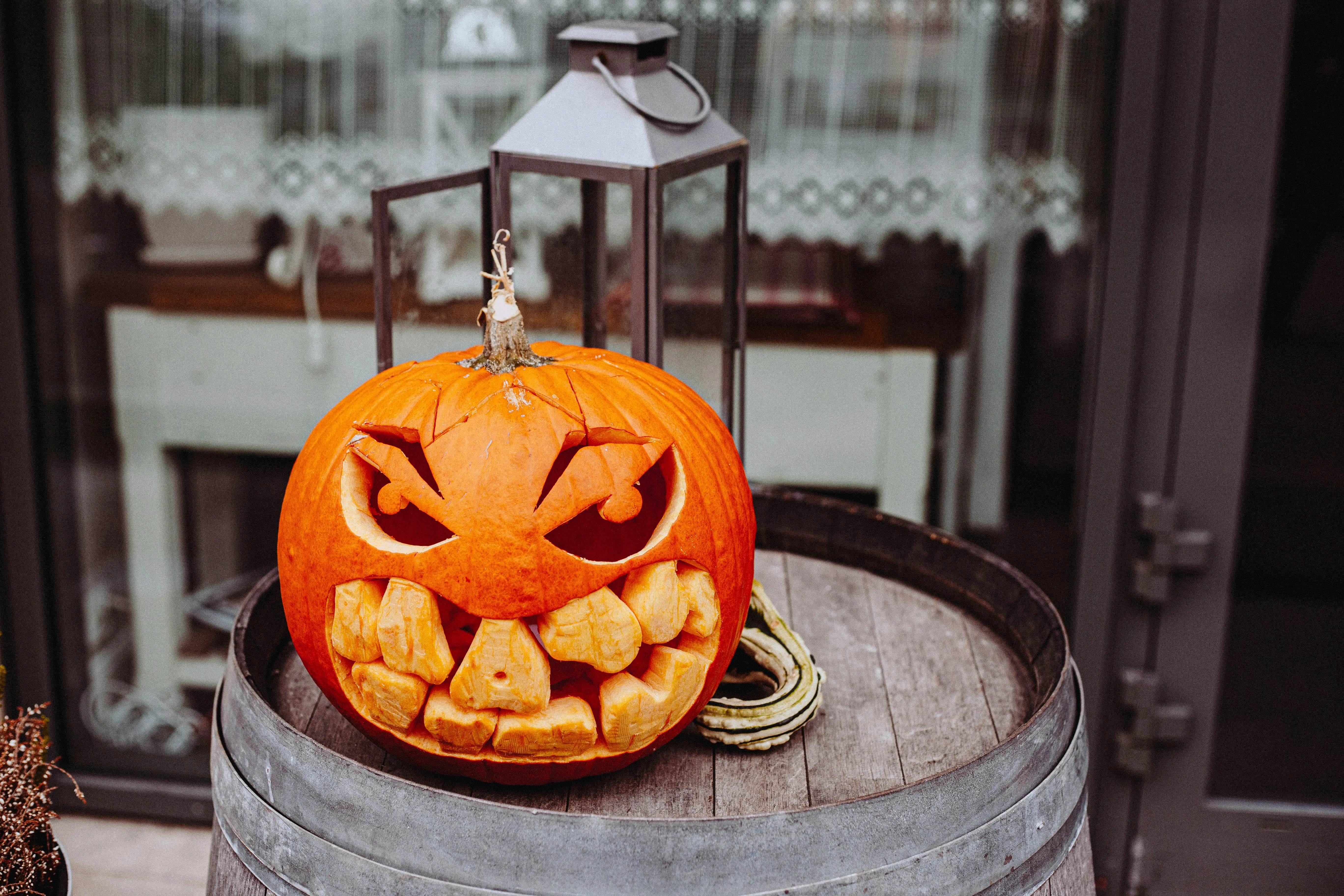 Scary Carved Pumpkin with Sharp Teeth on Wooden Drum