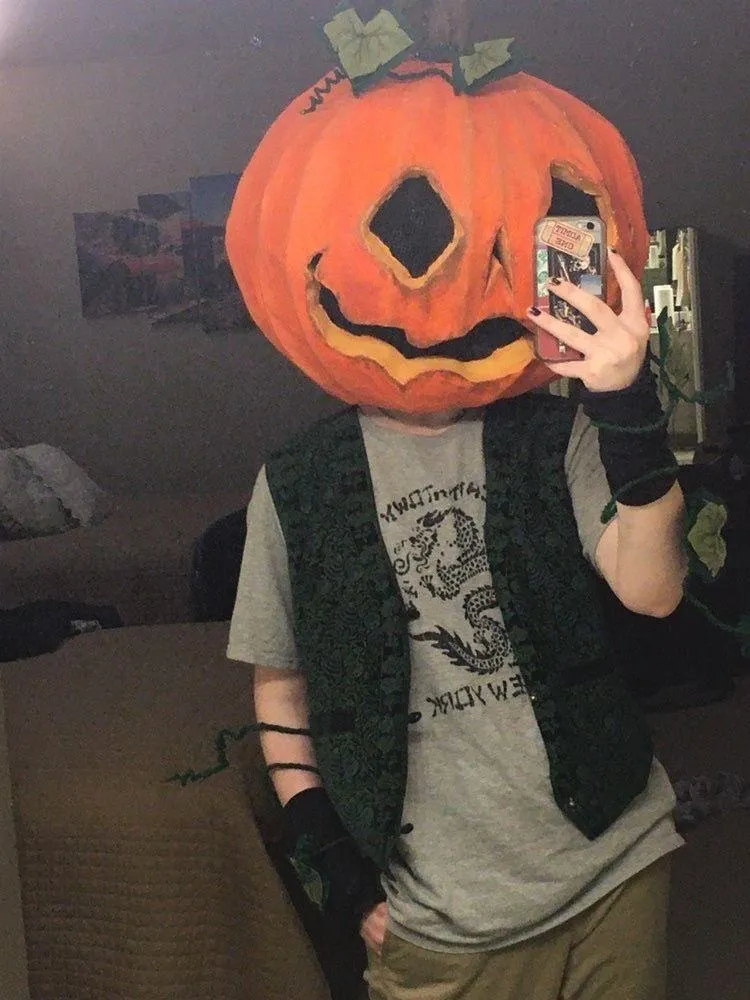 Selfie of Person Wearing Pumpkin Head Mask Indoors Wallpaper