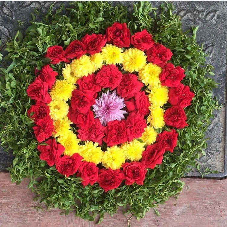 Simple kolam with Rose Marigolds and green leaves wallpaper
