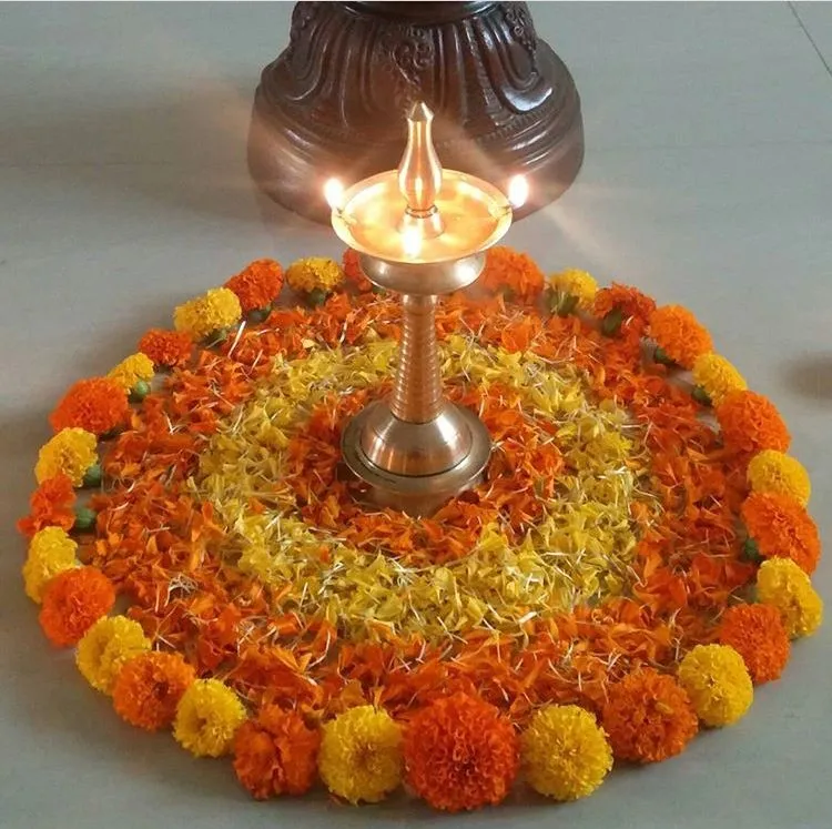 Simple Onam rangoli with marigolds and glowing lamp image